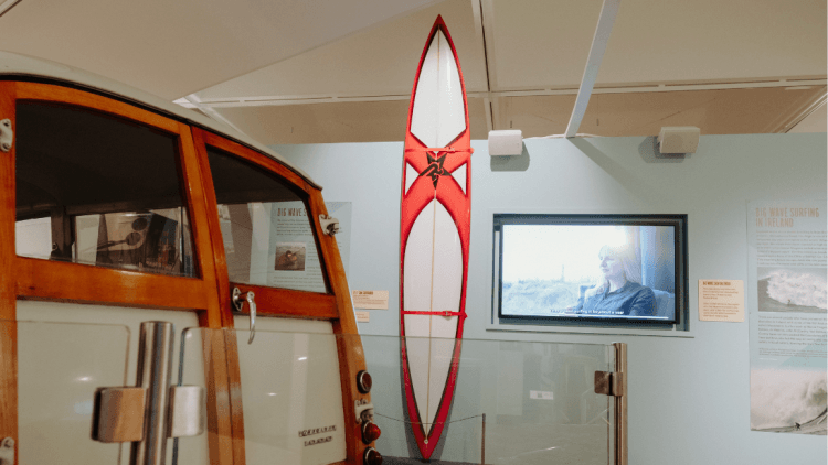 Red and white surfboard in the Celtic Wave exhibition at Ulster Transport Museum